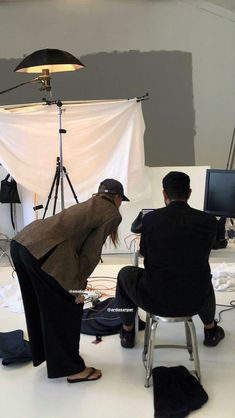 two people are sitting in chairs and one person is standing up to take a photo