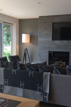 a living room filled with furniture and a flat screen tv mounted on the wall above a fire place