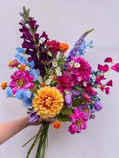 a person holding a bouquet of colorful flowers