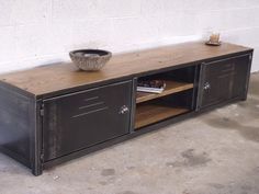 a black metal cabinet with a bowl on it's top and two shelves below