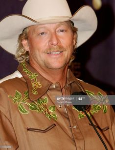 a man wearing a cowboy hat and holding a microphone