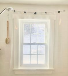 a white bathroom with a window and shower curtain