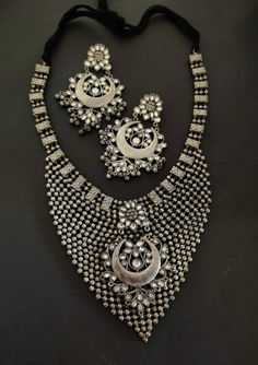 Add style and charisma to your beautiful personality with this exquisitely designed and handcrafted high quality silver look alike necklace set .Pair it up with any casual, semi formal or, formal attire and gather compliments for your unique and classy choice. Ideal wear for both casual and dressy occasions Necklace length 24 inches with an adjustable black dori at the back Weight 180 GM's Each earring weighs 20 GM's ( earrings are light weight and comfortable to wear) Length 3.5 inches Note: Al Traditional Hand Set Kundan Necklace, Bohemian Silver Jewelry With Stone Work, Metal Chandbali Jewelry Sets With Intricate Design, Silver Kundan Temple Necklace With Meenakari, Silver Meenakari Kundan Temple Necklace, Silver Metal Chandbalis For Wedding, Heavy Bollywood Metal Jewelry Sets, Bollywood Heavy Metal Jewelry Sets, Festive Metal Necklace With Stone Work