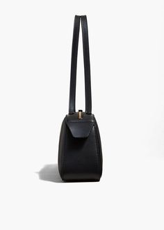 Simona Shoulder Bag in Black Leather – KHAITE LLC Minimalist Structured Bag With Gold-tone Hardware, Formal Structured Soft Leather Shoulder Bag, Modern Black Baguette Bag With Gold-tone Hardware, Black Structured Shoulder Bag For Evening, Modern Shoulder Bag With Long Strap, Elegant Baguette Bag With Adjustable Strap For Formal Occasions, Chic Evening Shoulder Bag With Long Strap, Modern Leather Bags With Long Strap, Modern Leather Bag With Long Strap