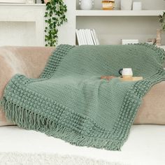 a green blanket sitting on top of a couch