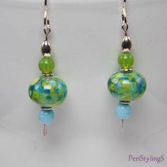 "These cheerful earrings are like a breath of Spring air! The focal beads made by a Georgia USA artist, have lovely shades of fern green and sky blue. Below are Cz glass sky blue round beads and above are Cz glass mantis green round beads. Set off with silver accents, the earrings hang 2\"(5 cm) from the top of the sterling silver handmade ear wires to the tip of the silver paddle pins. Comes in a beautiful gold or silver gift box, wrapped in a white iridescent fabric bag. Ready for gift giving, Hypoallergenic Turquoise Glass Earrings, Green Dangle Earrings With Spacer Beads, Green Round Beads Jewelry For Summer, Green Beaded Earrings For Summer, Hypoallergenic Glass Round Beads Earrings, Summer Green Jewelry With Round Beads, Hypoallergenic Green Round Bead Earrings, Elegant Green Hypoallergenic Beaded Earrings, Hypoallergenic Glass Bead Earrings