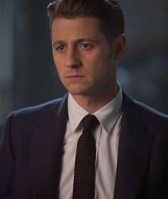 a man in a suit and tie looking at the camera with serious look on his face