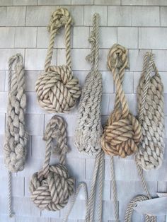 several ropes are hanging on the wall next to each other, with one knot in the middle