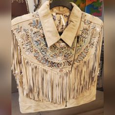 a white jacket with fringes and beads on it