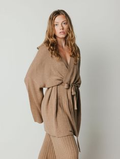 Wrap kimono cardigan in merino wool with open front, attached belted waist, and flared sleeve. Chic V-neck Kimono For Fall, V-neck Kimono For Fall Daywear, Fall V-neck Kimono For Daywear, Chic Shawl Collar Sweater Coat For Spring, Chic Spring Sweater Coat With Shawl Collar, Oversized V-neck Kimono For Fall, Belted Long Sleeve Kimono For Loungewear, Chic Fall Kimono For Loungewear, Long Sleeve Belted Kimono For Loungewear