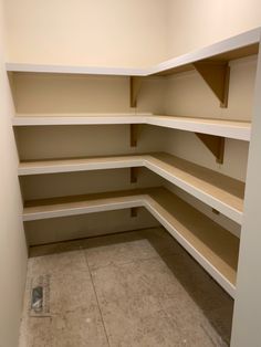 an empty walk - in closet with no one on the floor or shelves to be used for storage