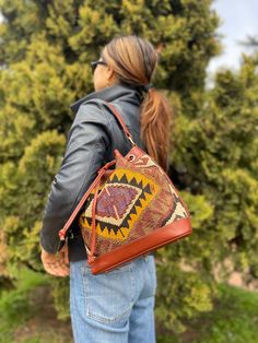 Thank you for visiting our shop!  It's very useful bag as shoulder and as crossbody bag.  This bag is spacious and holds a lot of things. Size         : 30cm x 27cm x 8cm Material  : wool / leather We select beautiful vintage kilims from all over the anatolian area and middle east area. and We do special wash for Kilim rug first, after that cut the kilim to remake unique kilim bags at our atelier  one by one. All products have been produced in a smoke-free environment.  Vintage kilim with colore Shoulder Bag With Dust Bag For Everyday Use, Bucket Hobo Bag For Travel, Bohemian Bucket Bag Backpack For Everyday Use, Bohemian Style Backpack Bucket Bag For Everyday Use, Bohemian Bucket Backpack For Everyday Use, Bohemian Shoulder Bucket Bag For Shopping, Bohemian Crossbody Bucket Bag For Shopping, Bohemian Bucket Bag With Adjustable Strap For Shopping, Travel Bucket Shoulder Bag With Leather Handles