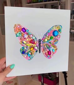 a person holding up a card with a colorful butterfly on it