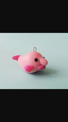 a pink plastic toy fish with black eyes