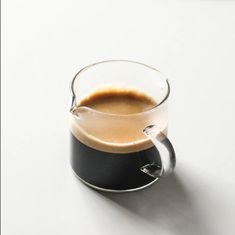 a glass cup filled with liquid sitting on top of a table