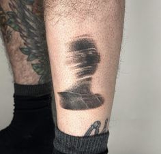 a man's leg with tattoos on it and his foot covered in black ink