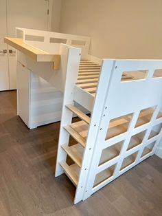 a bunk bed with two shelves underneath it and a desk under the bed for storage