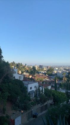 a view of the city from atop a hill with trees and buildings in the foreground