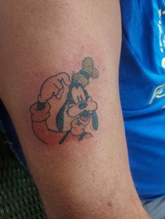 a person with a mickey mouse tattoo on their arm