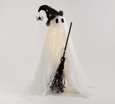 a white ghost with black eyes and a broom in its mouth is standing on a white surface