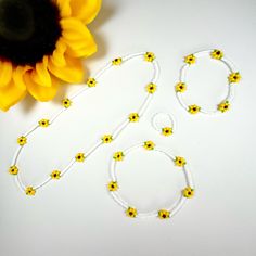 two bracelets and a sunflower on a table