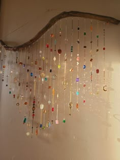 a wind chime hanging from the side of a wall with lots of beads on it