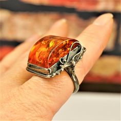 "LARGE AMBER STERLING Ring Size 9, Rare Big Baltic Honey Amber 925 Silver Rectangular Ring, Estate Amber Jewelry, Unique Holiday Gift For Her by ANTIQUE4YOU AMAZING OLD ART NOUVEAU GENUINE AMBER LARGE STONE and STERLING SILVER RING. BEAUTIFUL STERLING DECOR FROM ONE SIDE. SIZE US 9. HALLMARKED 925. UPPER PART 1 1/8\" x 1\" x 1/2\" . HIGH SETTING UNUSUAL 3D COGNAC AMBER STONE WITH A LOT OF INCLUSIONS. GREAT RARE GIFT FOR HER. UNISEX RING." Elegant Amber Ring With Large Stone, Antique Amber Rings For Collectors, Sterling Silver Amber Jewelry With Large Stone, Fall Wedding Ring, Unique Amber Sterling Silver Rings, Amber Antique Sterling Silver Jewelry, Glitter Ring, Rare Gifts, Unique Holiday Gifts