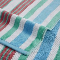 a close up of a towel on top of a bed with blue, green and red stripes