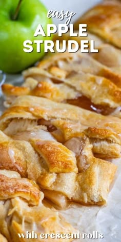 an apple strudel is cut into pieces and sitting on top of wax paper