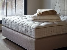 a mattress is stacked on top of each other in front of a window with glass doors