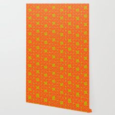 an orange and green wallpaper with small squares on the bottom, in front of a white wall