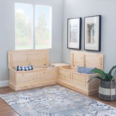 a living room with wooden storage boxes on the floor next to a rug and two framed pictures