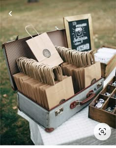 an open suitcase sitting on top of a table filled with paper bags and other items