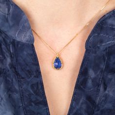 This teardrop Tanzanite is a lovely, deep sea blue. This one-of-a-kind gemstone is set in a handmade gold setting accented with braided gold and prongs. It’s strung on an 18k yellow gold chain. Technical Details Metal: 18k yellow goldTanzanite: 4.36 cts. Pendant Size (not including bail): 14mm x 10mmChain: can be worn at 16" and 18"Closure: lobster claspHandmade in New YorkStyle # N-3399-TA Pear-shaped Gemstone Drop Necklace In Yellow Gold, Yellow Gold Pear-shaped Gemstone Drop Necklace, Gold Teardrop Sapphire Necklace, Yellow Gold Teardrop Gemstone Drop Necklace, Teardrop Tanzanite Jewelry In Yellow Gold, Gold Tanzanite Teardrop Jewelry, Tanzanite Teardrop Gemstone Jewelry, Sapphire Teardrop Jewelry With Gemstone Accents, Teardrop Tanzanite Gemstone Jewelry