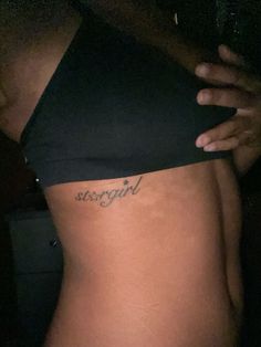 a woman's stomach with the word virgin tattooed on it