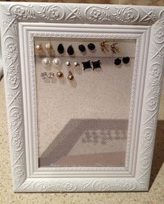 a white frame with several pairs of earrings in it