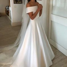 a woman in a white wedding dress is posing for the camera