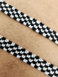 two black and white braided bracelets laying next to each other