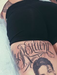 a woman with a tattoo on her stomach is laying down and has the word marilyn written in cursive writing