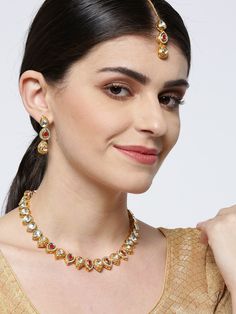 This handcrafted jewelry set consists of a necklace, a maang tikka and a pair of matching drop earrings. The necklace has a maroon color-theme with green accents, comes with kundan stone studs, is gold-plated, and secured with an adjustable drawstring closure. A matching maang tikka comes with kundan stone studs, is gold-plated, and can be secured with a hook closure. A pair of matching drop earrings come with kundan stone studs, are gold-plated, and are secured with a post and back closure. The Kundan Bridal Necklace With Latkans, Traditional Kundan Bridal Necklace With Latkans, Traditional Jeweled Kundan Necklace, Festive Dual-tone Gold Plated Jewelry, Gold Kundan Jewelry Set For Navratri, Dual-tone Kundan Jewelry, Dual-tone Kundan Temple Jewelry Sets, Bollywood Style Dual-tone Chandbali Jewelry Sets, Bollywood Style Dual-tone Festive Jewelry Sets