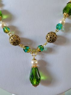 Peridot glass bead necklace. A beautifully handmade necklace with faceted glass teardrop beads as well as a mix of vintage brass filigree beads and faux pearls. This necklace is finished with a delicate chain and a push fit fastener, measuring roughly 18 inches in length. Green Drop Necklaces For Party, Green Drop Necklace For Party, Gift Teardrop Faceted Bead Crystal Necklace, Green Czech Glass Necklaces For Party, Wire Wrapped Czech Glass Dangle Necklaces, Wire Wrapped Czech Glass Pendant Necklace, Party Necklaces With Beaded Czech Glass Chain, Party Necklace With Beaded Czech Glass Chain, Party Necklace With Czech Glass Beaded Chain