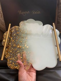 a person holding a tray with gold flakes on it