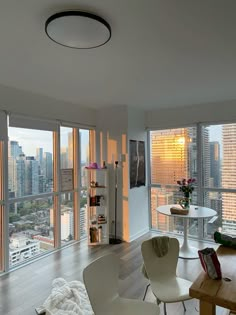 a living room filled with furniture and large windows overlooking the cityscape in the distance