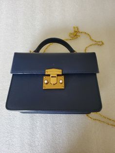 "This listing is for a Designer Bag made by \"Charles & Keith\" in a blue pebbled hard body Top Handle purse. The hardware is in a gold tone with two white faux pearl cabochon accent on the clasp. On the top is a small hard handle with two side rings for adding a chain to make it a crossbody. This purse came all the way from Delta, Colorado it was in consignment shop. I did pay up for this handbag and it appears to be in mint conditions. Please look at the photos and video for more details. The Luxury Blue Box Bag With Detachable Handle, Affordable Blue Top Handle Box Bag, Luxury Blue Square Satchel, Classic Blue Rectangular Box Bag, Blue Box Bag With Detachable Handle For Evening, Classic Blue Shoulder Bag With Chain Strap, Blue Evening Shoulder Bag With Metal Hardware, Evening Blue Shoulder Bag With Metal Hardware, Formal Blue Shoulder Bag With Metal Hardware