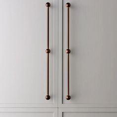 an image of a door handle on the front of a white cabinet with brass handles