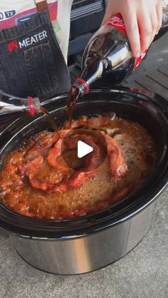 a person pouring sauce into a slow cooker