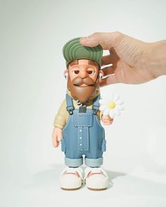 a hand is holding a toy with a man's head