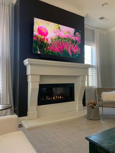 a living room with a large television mounted on the wall and a fireplace in front of it