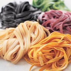 four different types of pasta on a white surface