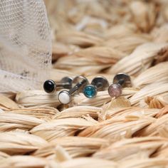 three pairs of earrings sitting on top of a woven basket